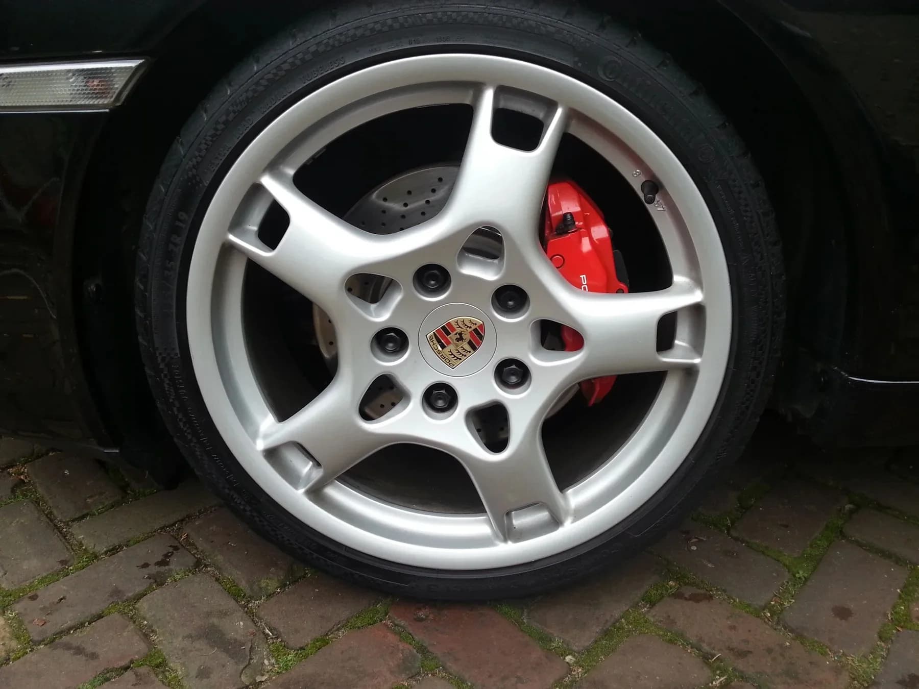 Detail van een gereinigd wiel en de zichtbare remklauw.