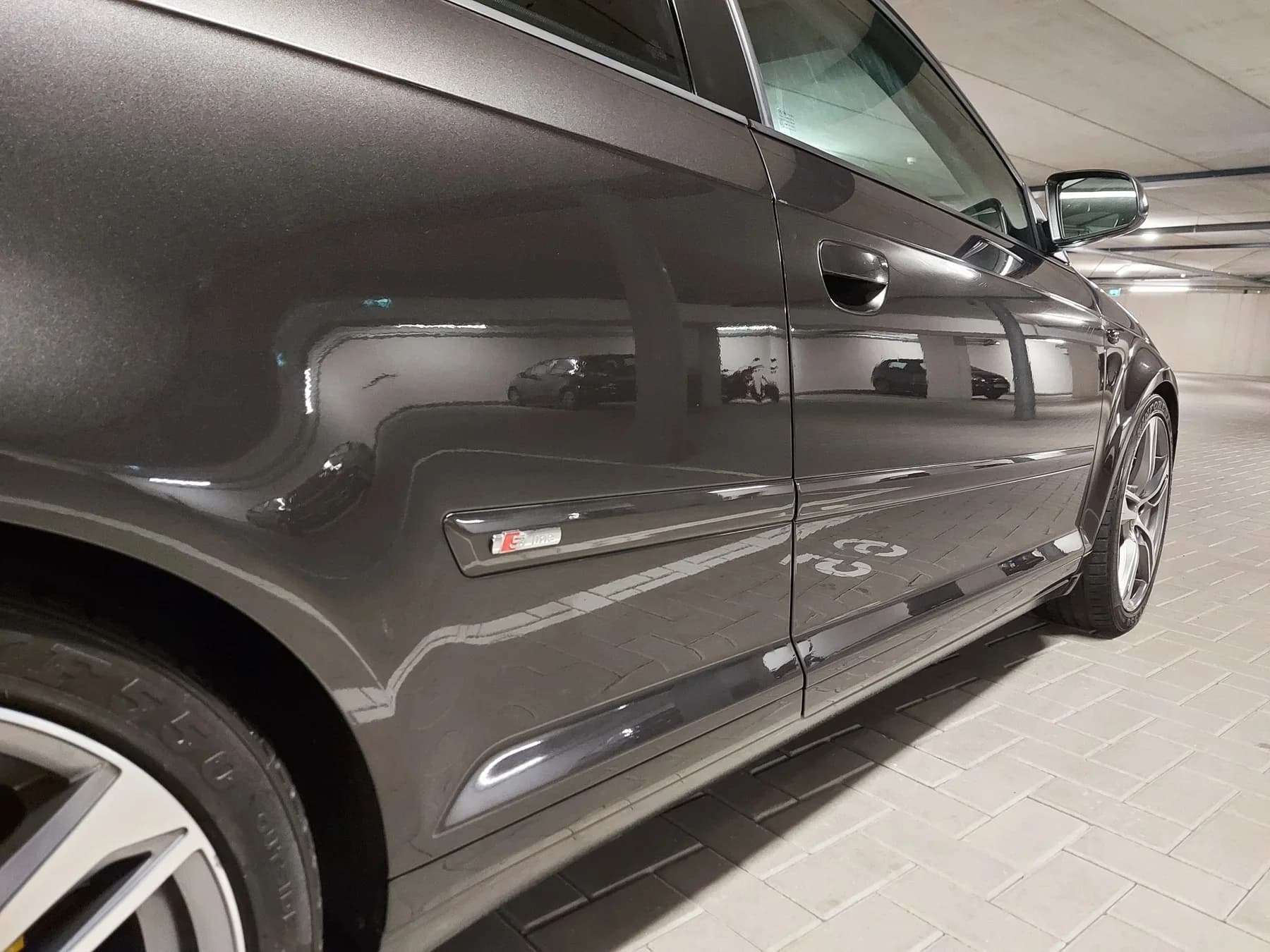 Grijs carrosseriedetail met verzorgde lakafwerking.